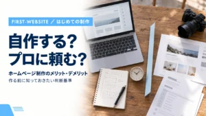 ノートパソコンとデザイン資料が置かれたデスクで「自作する？プロに頼む？」と問いかけるホームページ制作のメリット・デメリットのアイキャッチ画像